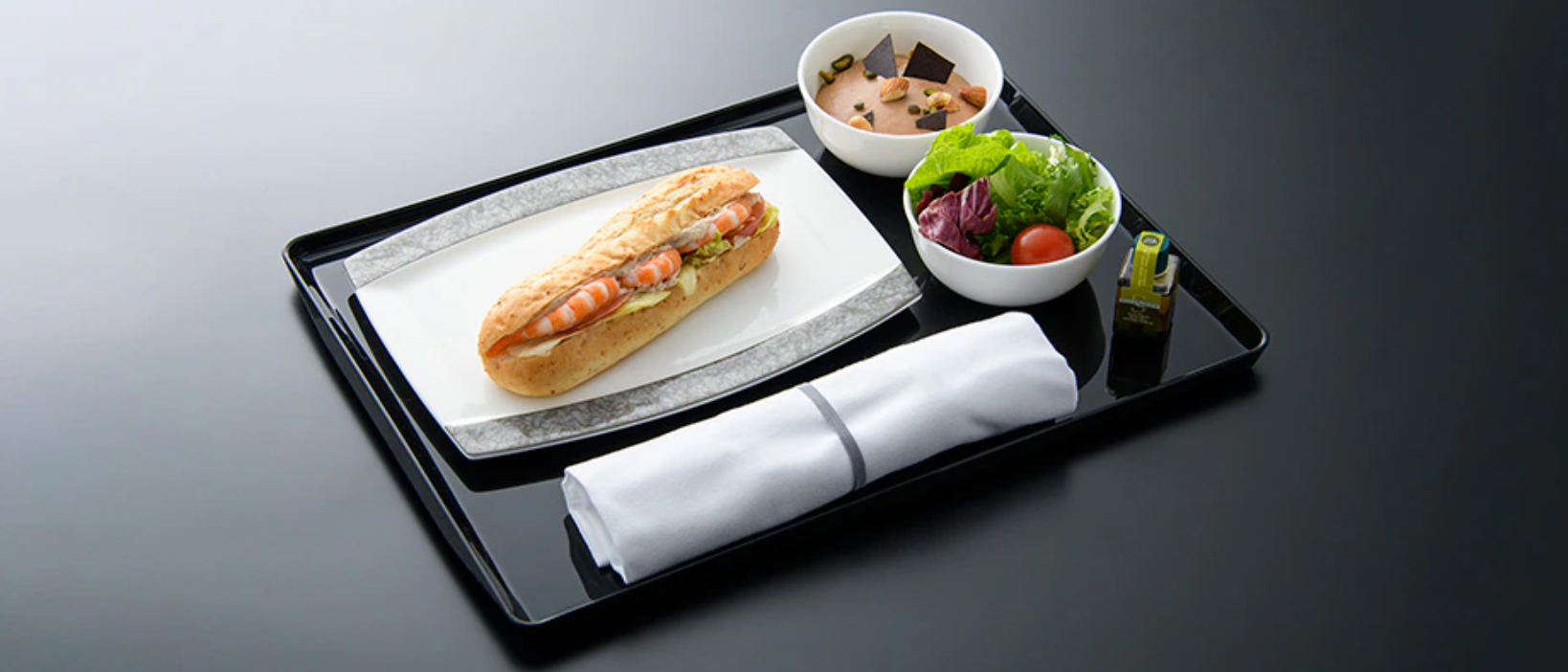 サービス内容:機内食サービスを手短に済ませたいお客様向けのサービスです。離陸後に提供するコースのお食事(アミューズ・前菜・主菜・デザート)に変えて、ワントレー(サラダ・サンドイッチ・デザートの3品)のお食事を提供します。軽めのお食事を、手早くお召し上がりいただき、お食事サービスを早めに終えていただけます。